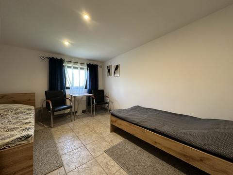 Pokój z dwoma łóżkami, stołem i krzesłami – hostel pracowniczy Częstochowa (1/4)